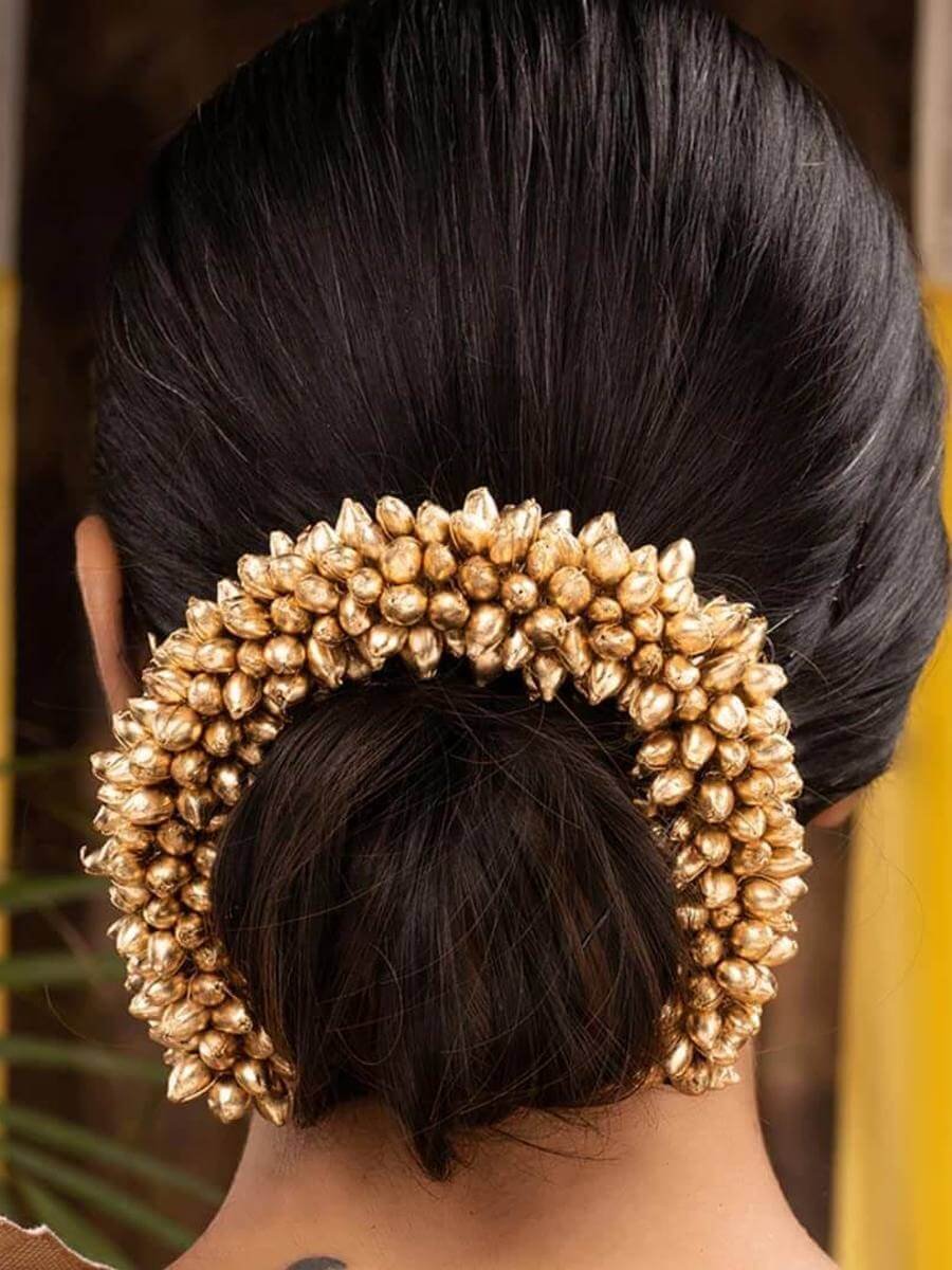 Golden bead garland wrapped around a low bun
