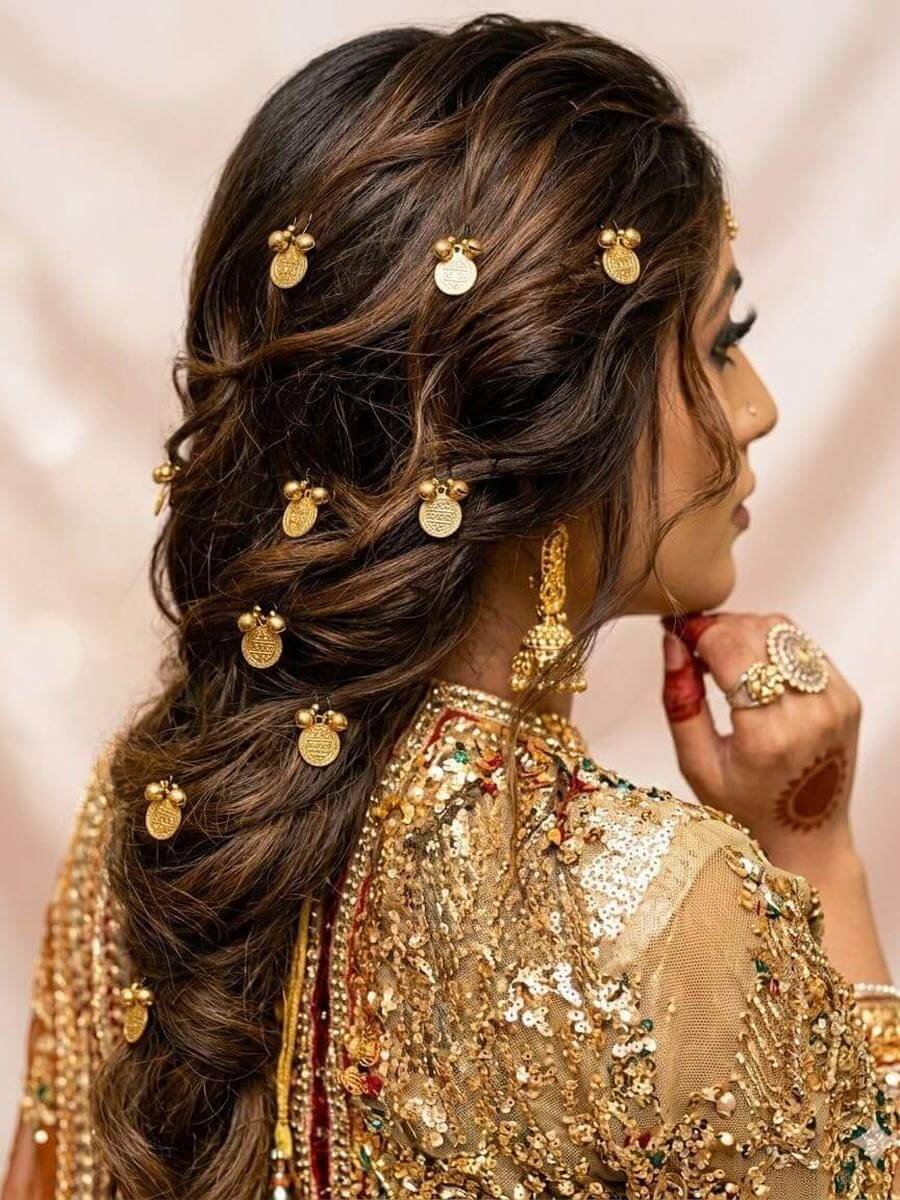 Small gold coin pins scattered through curled hair