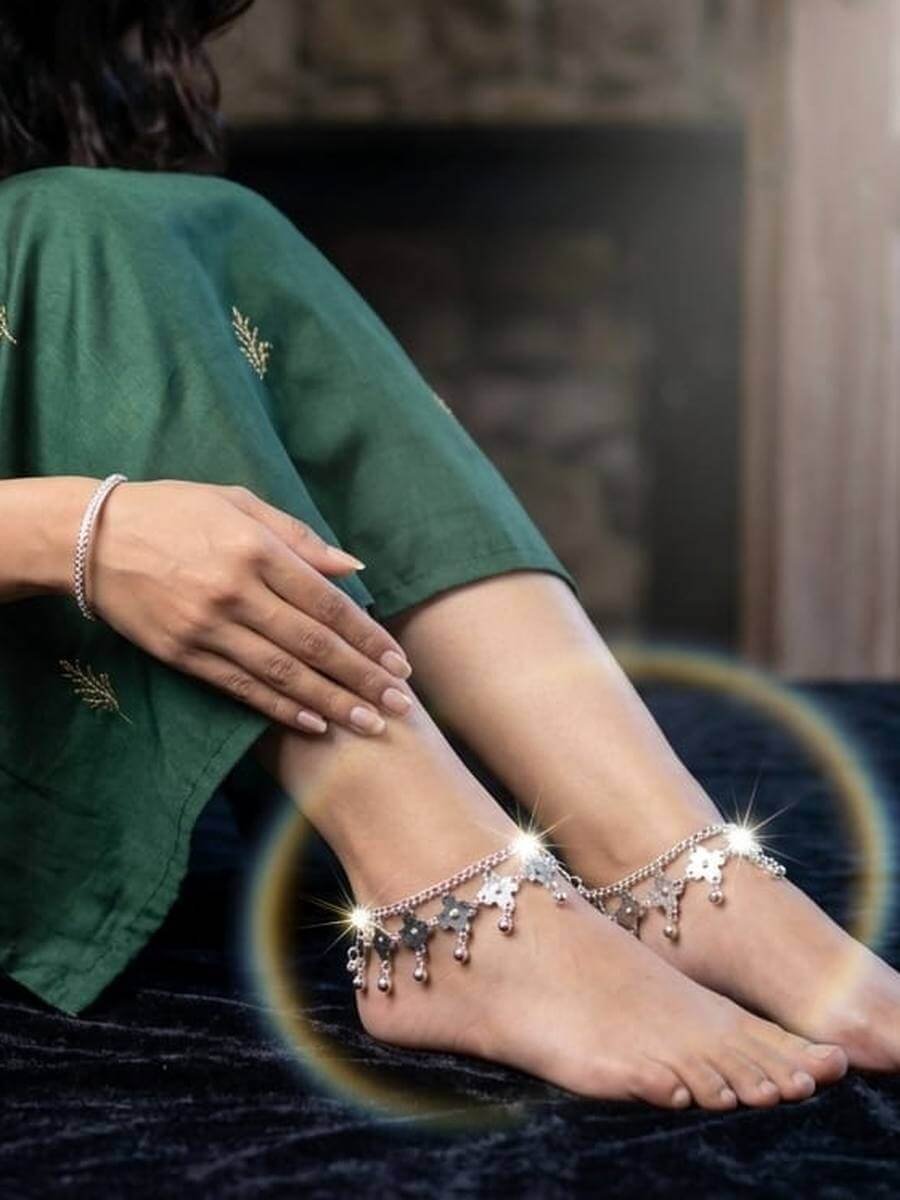 Silver bracelet and a pair of flower-drop anklets worn with a green suit